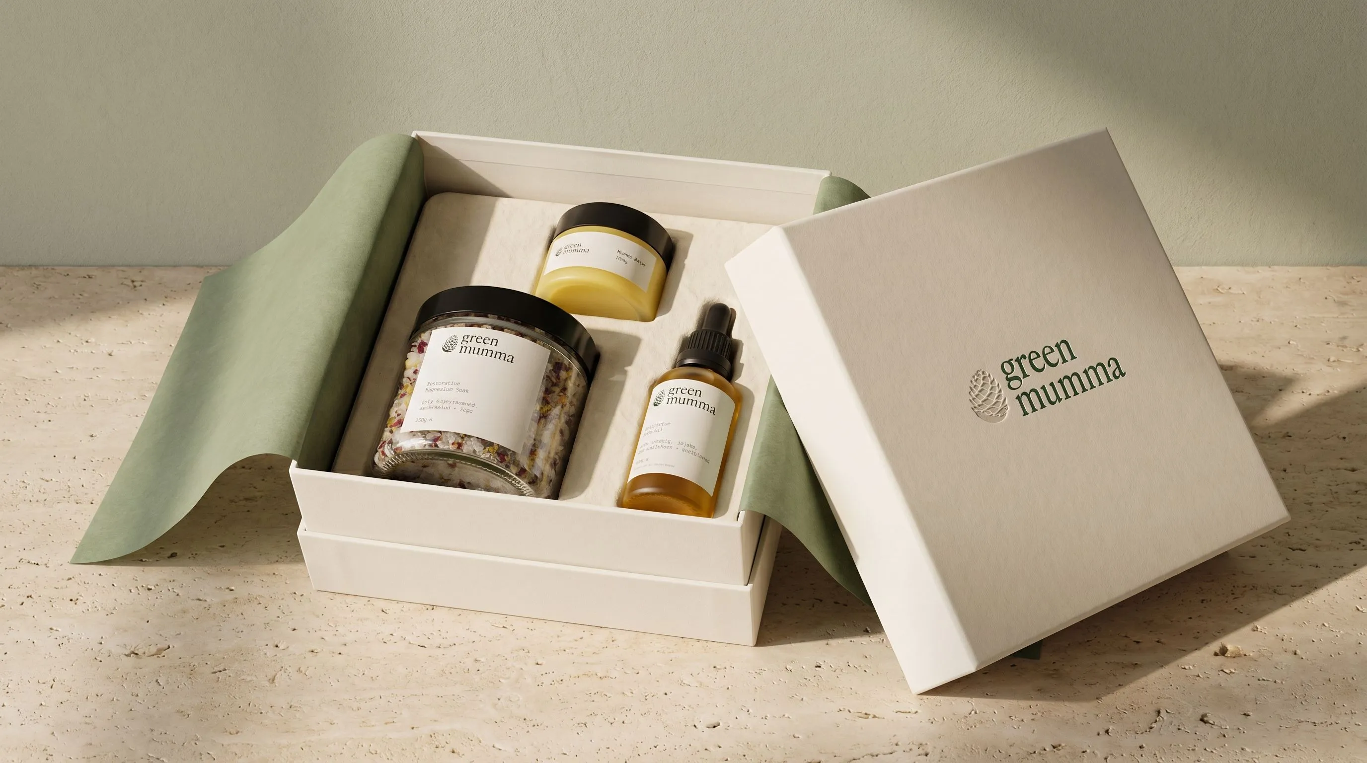 The Postpartum Ritual gift box open, showing all three products in a pulp insert under sage tissue
